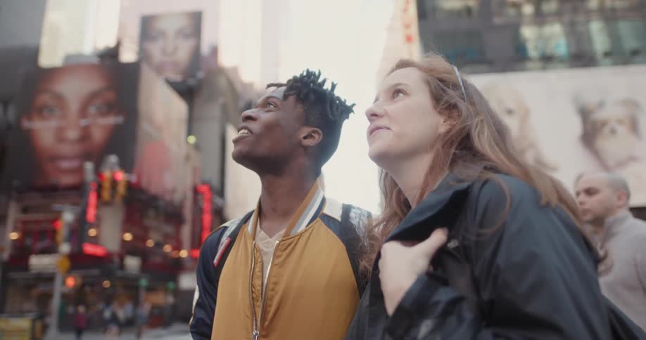 A young man and woman look around the city