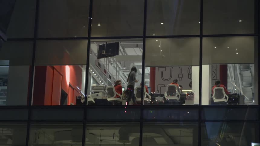 People are walking past the window in the building across the way