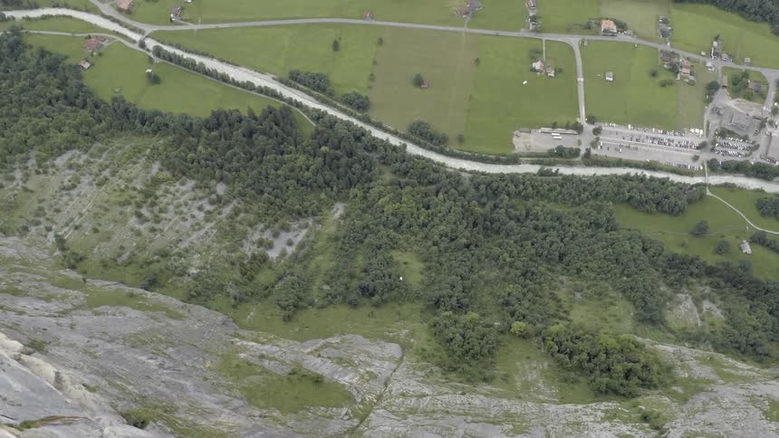 A person in a wing suit jumps from a sharp cliff