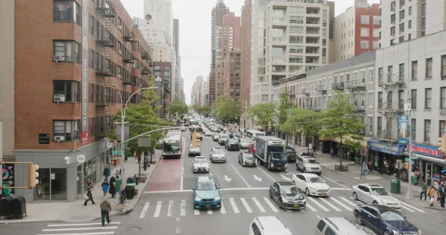 Many vehicles drive down a busy city street
