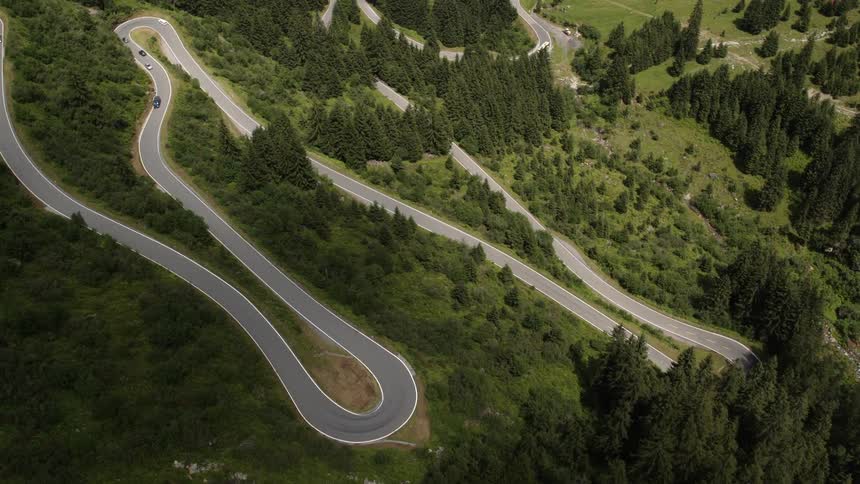 The winding roads have a few vehicles traveling around