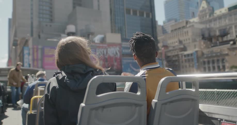 Man and woman sit in chairs at an outdoor event in the city