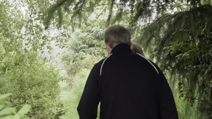 A couple are walking on a nature trail in daylight