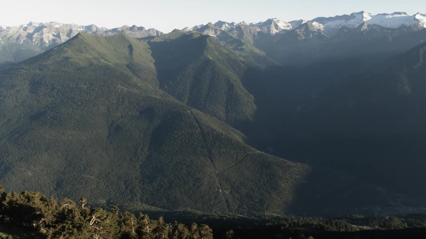 The mountain range is covered with green and snow
