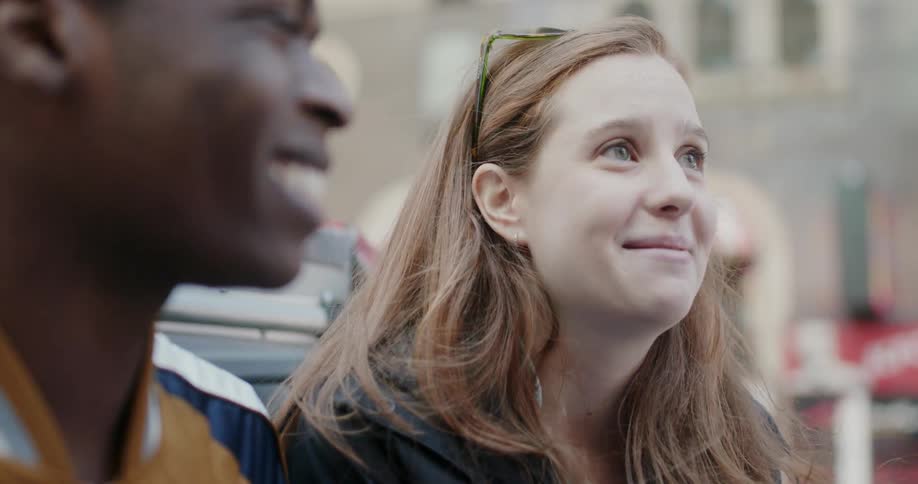 A woman laughs and talks with someone outside