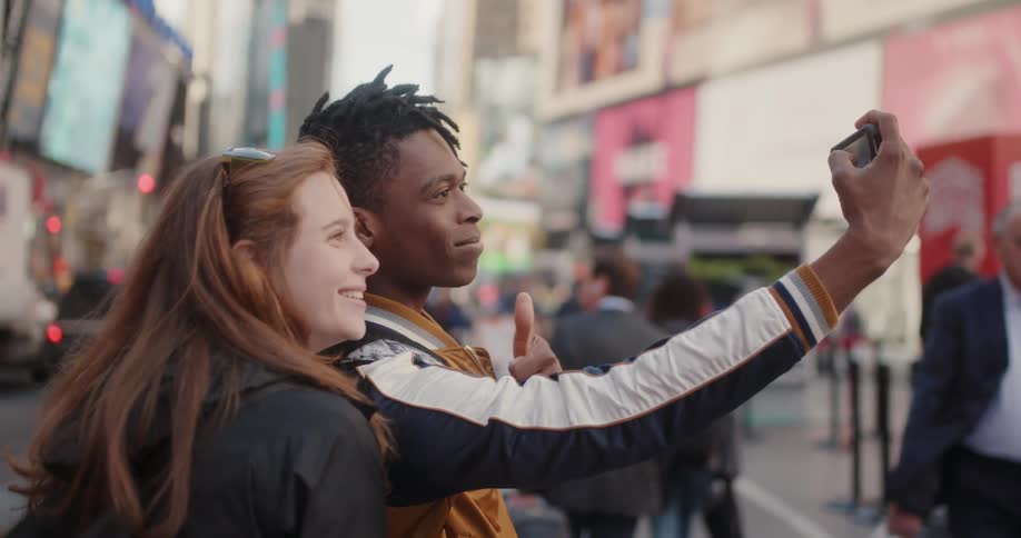 A man takes a photo with a girl using a phone