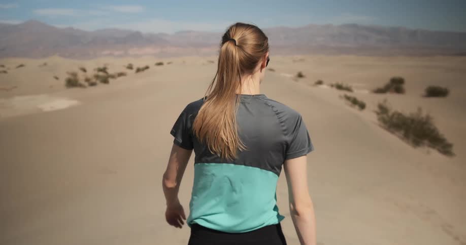 A woman walks in the desert