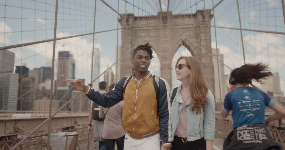 A couple walk across the large bridge together