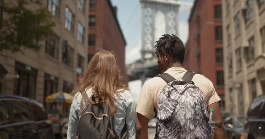 Man and woman walk down a busy city street