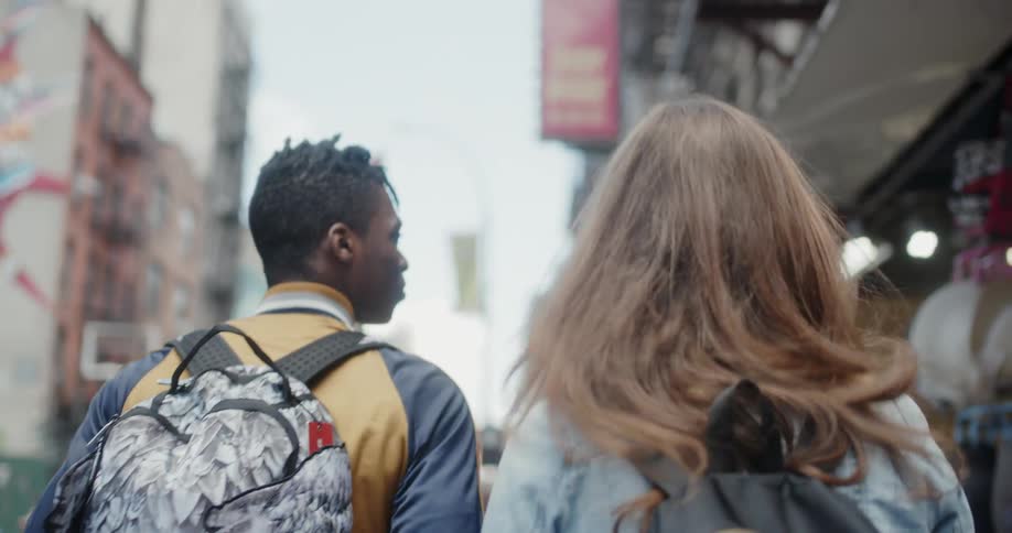 Man and woman walk down a busy city street