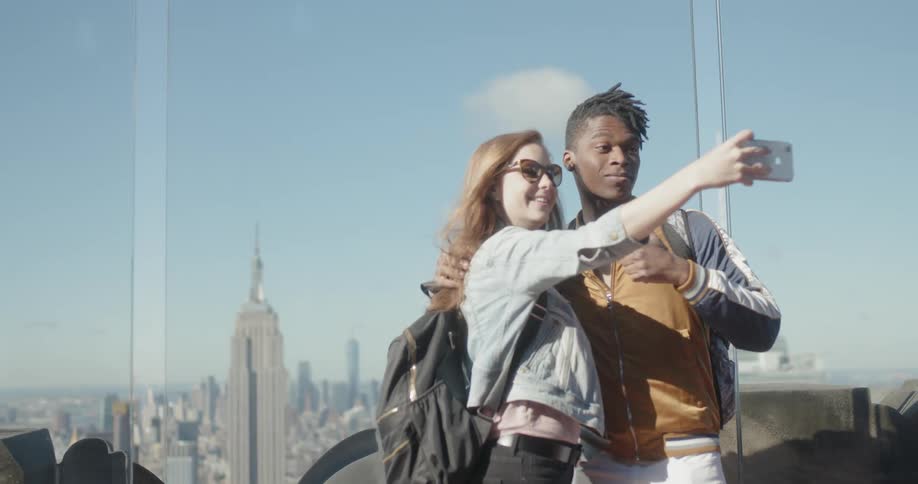 A woman takes a picture with a man on a windy day