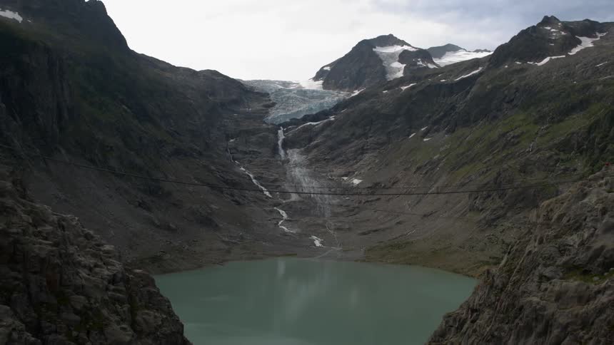 A hidden emerald lake lies between unwelcoming cliffs