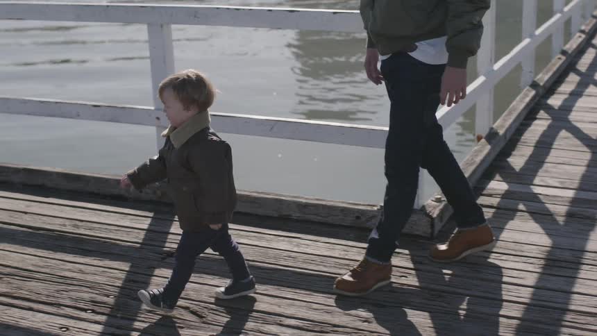 A child climbs on the bench in the pier