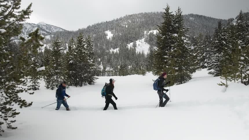 People are hiking through the tall snow in a line