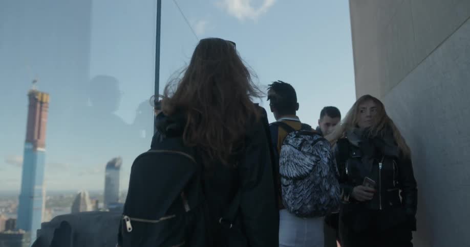 People walk past a building on a sunny day