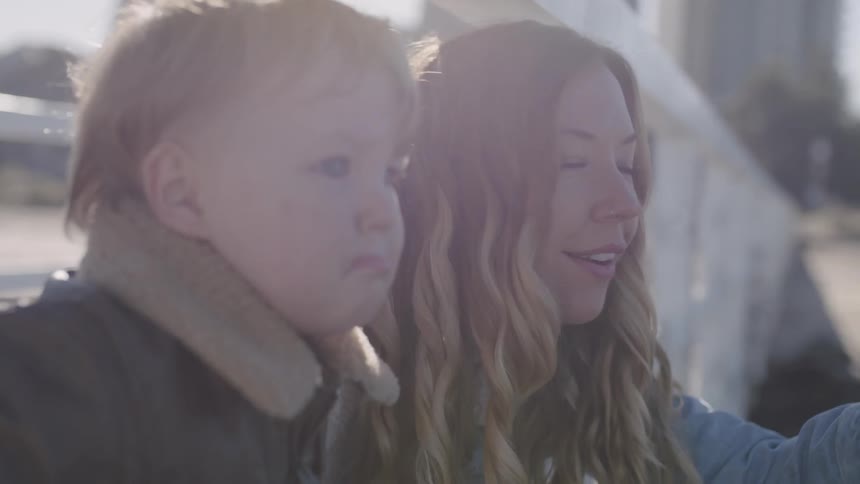 A woman talks with a toddler outside