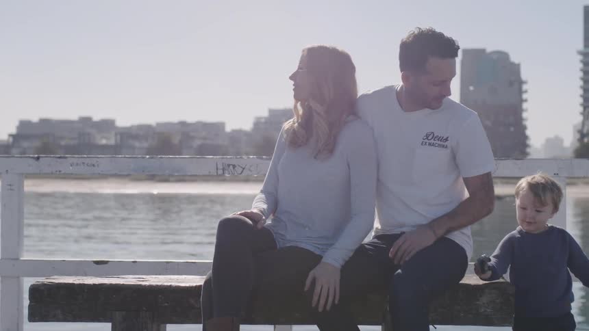 A man and woman kiss on the pier
