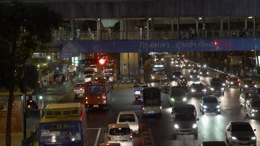 The cars are moving slowly on the road at night