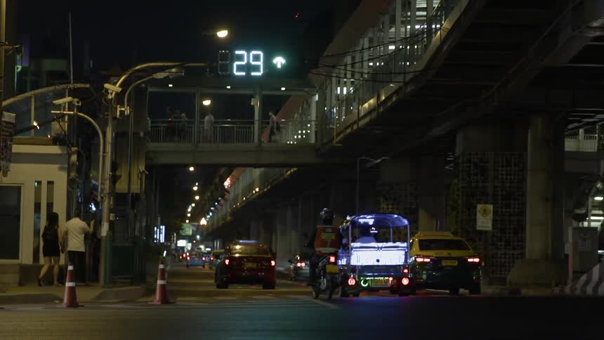 The cars travel under the train platform at night