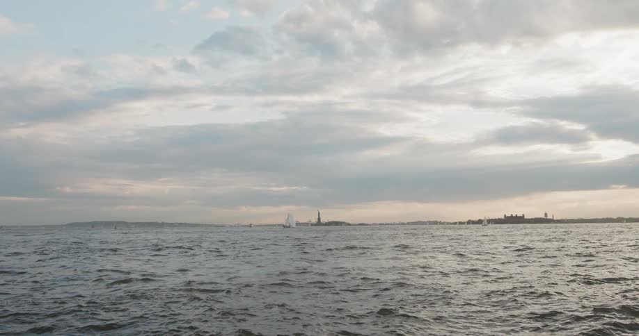 The sail of a sail boat and land are visible on the horizon