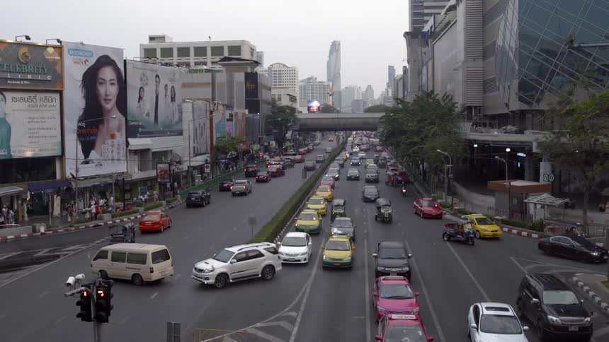 Cars drive down a busy city street