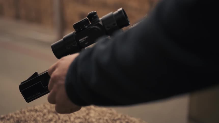 Person loads a gun and gets ready to shoot it