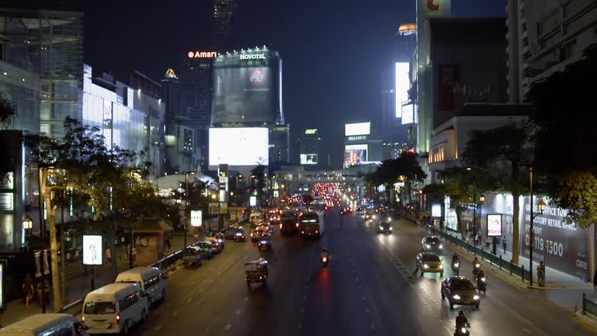 The city is busy at night with many vehicles on the road