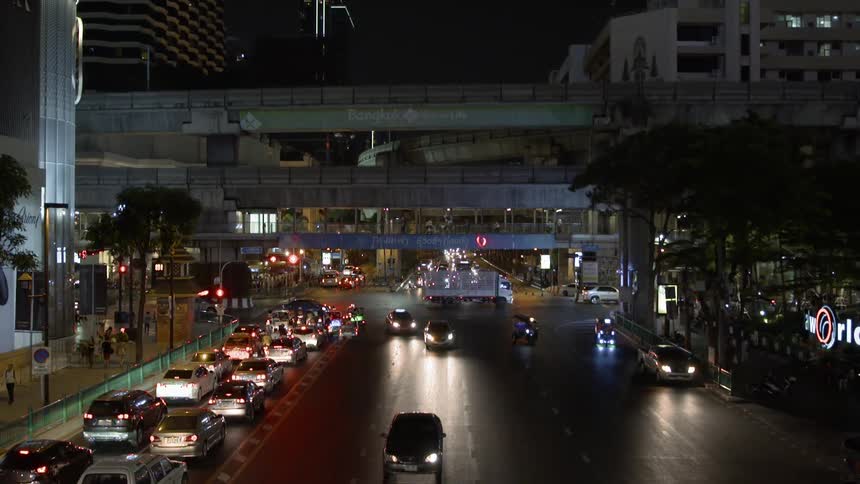 The cars make turns on the city street at night