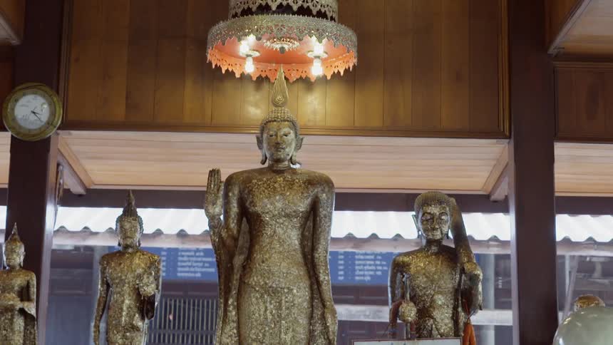 Asian statues are displayed and one holds a sign