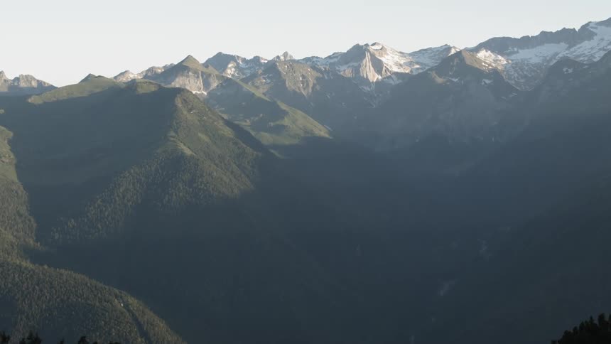 A man stands looking out onto the mountains