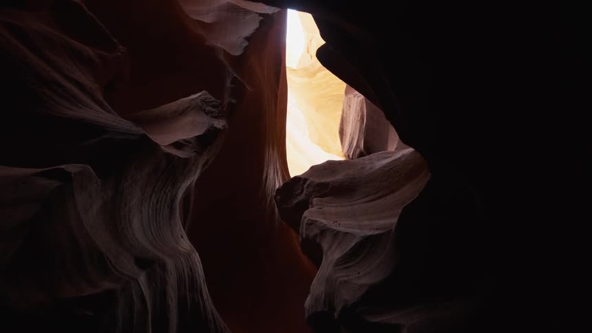 The cave is dark with sun only peeking in from above