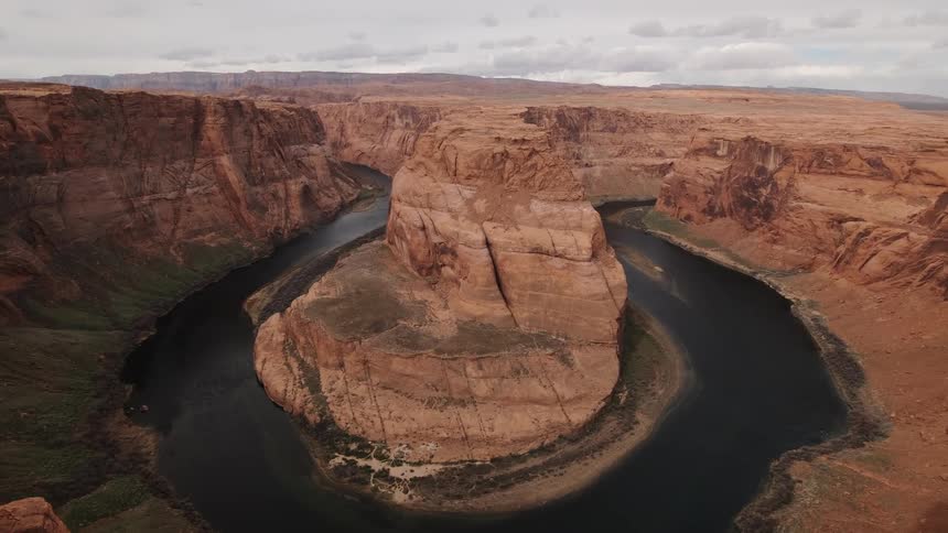 The water is surrounded the large rock in the canyon