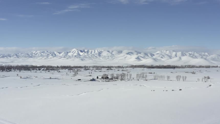 The snow covered field leads to a mountain range