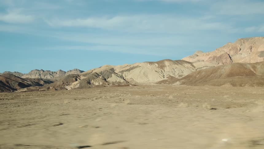 The desert leads to some mountains on a cloudy day