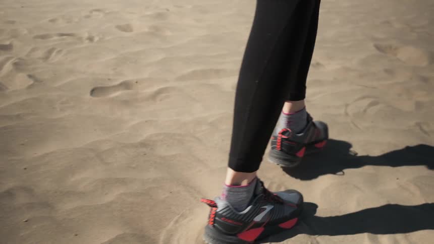 A person is walking in the sand