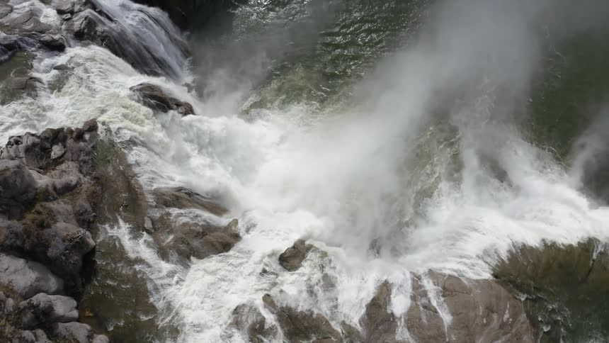 Waterfall splashes down rocks into a pool below