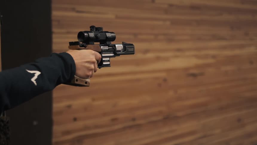 A person fires a scoped handgun