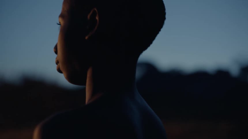 Child looks at a burning building at night