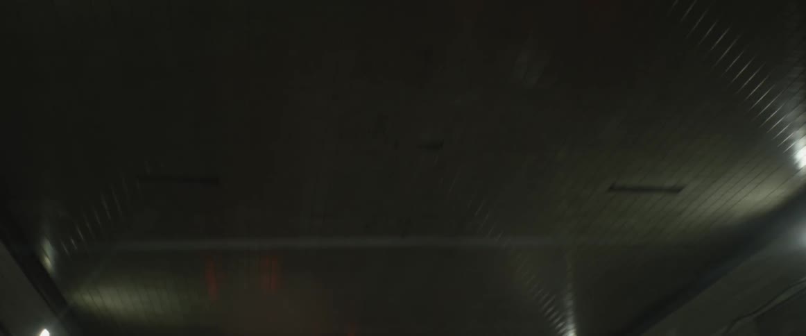 Car lights are reflected off the roof of a tunnel