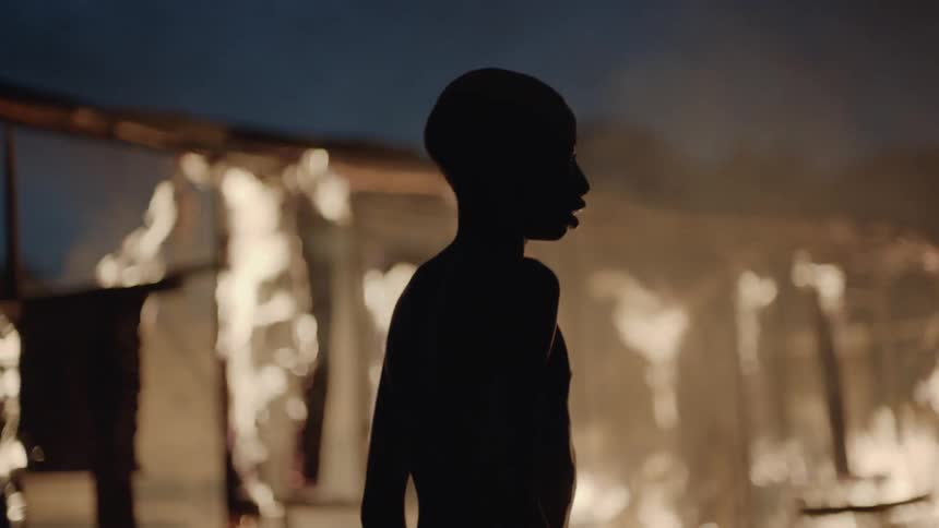 Boy watching a house on fire