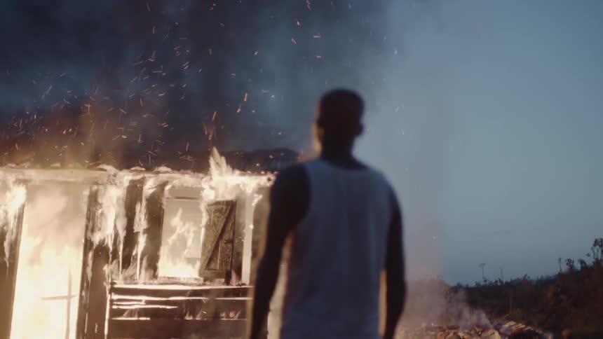 Man watches a house burn