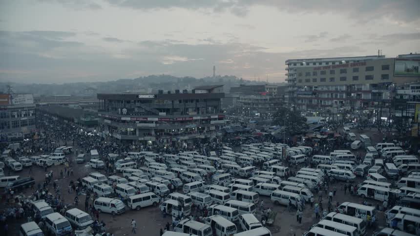 Vans and pedestrians cover a city parking lot