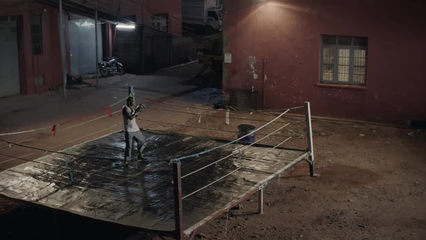 Man boxes alone in an outdoor boxing ring