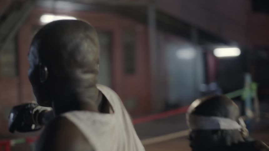 A boxer is wandering away after taking a swing at an opponent outside at night