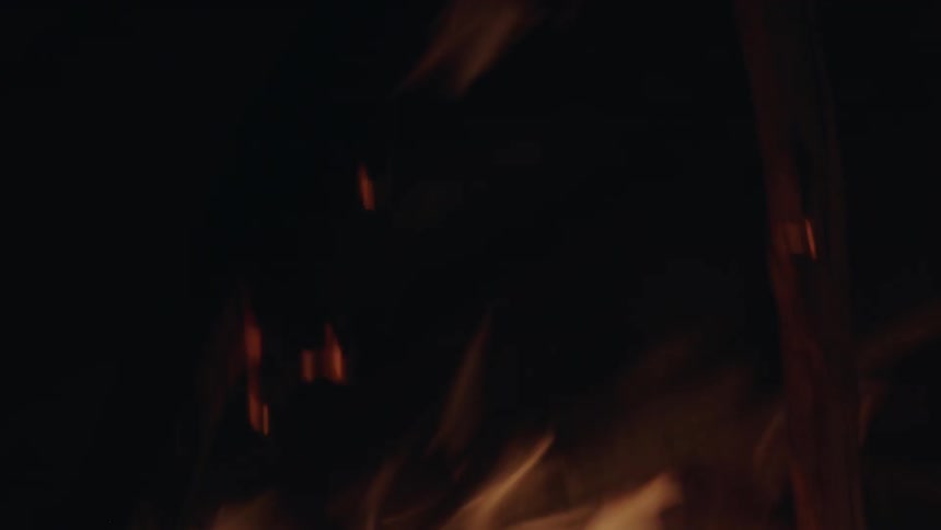 Flames are destroying a wood structure at night