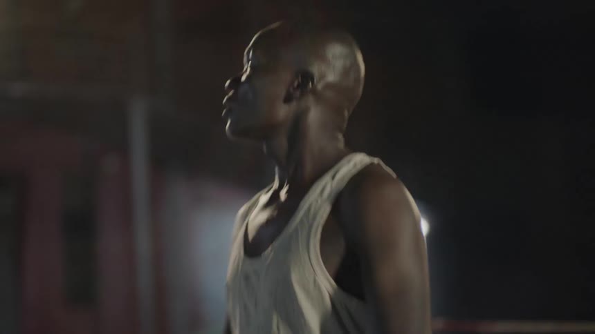 Man spins around in an outdoor boxing ring at night