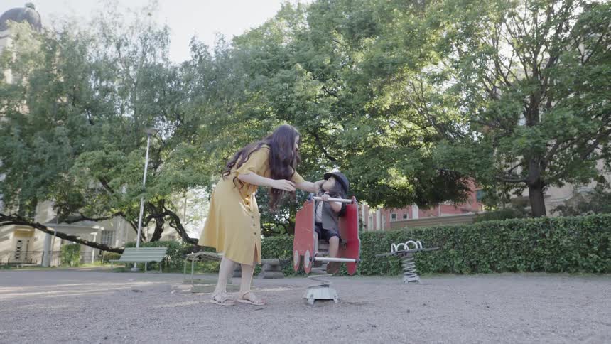 A woman and young child play at a park