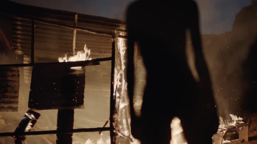 Child watches a building burn at night