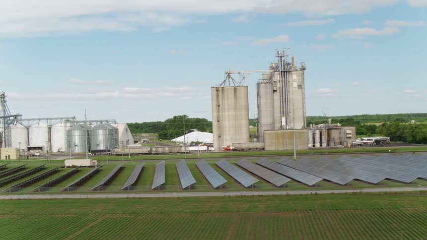Solar panels and silos sit on a farm
