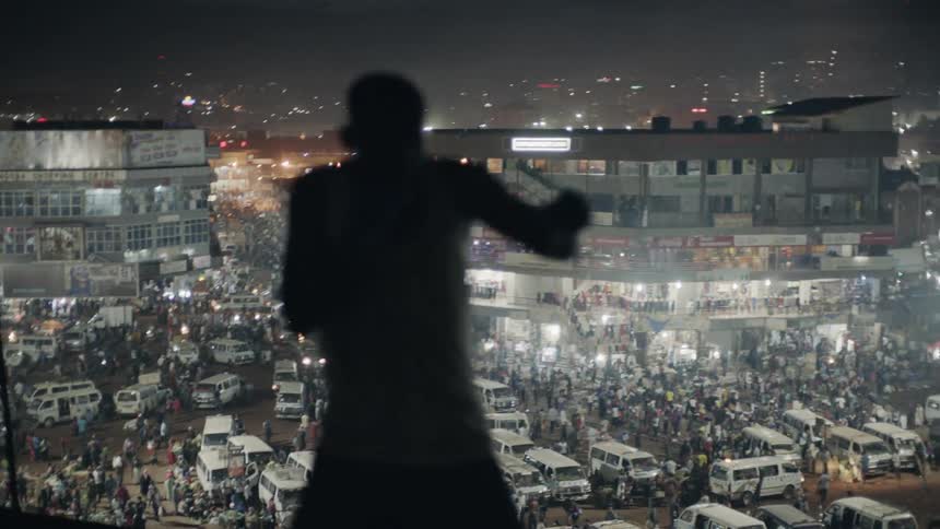 A boxer is shadow boxing on a rooftop at night
